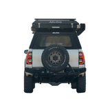 Back view of a vehicle with an Alu-a Cab Explorer Canopy and Gen3.R rooftop tent and  spare tire mounted. Camp4x4 camp 4x4, overlanding, camping