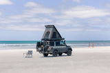 Camper van with an Alu-Cab rooftop tent on a sandy beach. Camp 4x4, Available at Camp4x4. Overlanding Products and fitments. Camping
