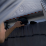 Close-up of the Alu-Cab Shower Cube Adjustable Curtain and shelf with dark blue fabric with a buckle. Camp 4x4