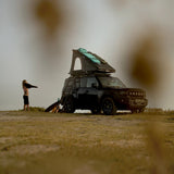 A Camp4x4 rental vehicle, fitted with the Alu-Cab LT-50 Lightweight rooftop tent, which is opened up in a grassy campsite