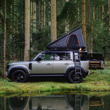 A Camp4x4 rental vehicle, fitted with the Alu-Cab LT-50 Lightweight rooftop tent, in a forrest setting