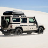 Rear view of a Alu-Cab RT-2S Rooftop Tent mounted on a Camp4x4 rental vehicle in sandy enviroment