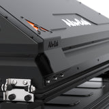 Close-up of a black Alu-Cab RT-2S Rooftop Tent with visible branding, showing the corner latch and matte black metal construction.