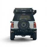Back view of a vehicle with an Alu-a Cab Explorer Canopy and Gen3.R rooftop tent and  spare tire mounted. Camp4x4 camp 4x4, overlanding, camping