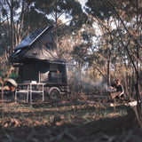 camp4x4.co.za Someone sitting at a camp site with an Alu-Cab Gen3-R Hardshell Rooftop Tent fitted to a trailer