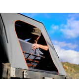 camp4x4.co.za Someone sitting in an Alu-Cab Gen3-R Hardshell Rooftop Tent and positioning the Backrest.