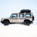 Alu-Cab RT-2S Rooftop Tent mounted on a Camp4x4 rental vehicle, in sand dunes