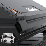 Close-up of a black Alu-Cab RT-2S Rooftop Tent with visible branding, showing the corner latch and matte black metal construction.