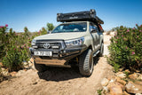 Toyota Hilux offroad vehicle fitted with the Alu-Cab Roof Box. A sturdy aluminum storage box fitted with the Alu-Cab Jerry can Holder