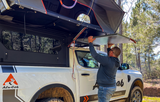 Alu-Cab MODCAP Family Tent Table Slide Fitted to an off-road vehicle in nature, with a person removing the Alu-Table