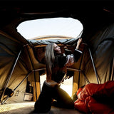 A woman upening the skylight in the Front Runner Feather-Lite II Rooftop Tent