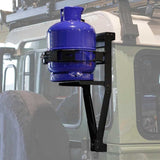 A blue gas tank mounted on a Front Runner Land Rover Defender 90/110 Single Gas Bottle Bracket attached to the gutter of a light-colored vehicle.