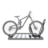 A bicycle Mounted on a Front Runner Pro Bike Carrier rack fitted to a Roof Rack, shown with a semi-transparent gray mountain bike overlaid to demonstrate use. Photographed on a plain white background.