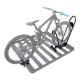 A gray slatted roof rack on a white background, shown with a semi-transparent gray mountain bike secured to a Front Runner Pro Bike Carrier.