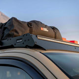 Roof rack system on a car with a Light Bar and cargo bag attached, featuring 'Front Runner' branding.