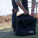 A man removing a Front Runner camping chair from a storage bag in the outdoors