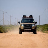 Toyota SUV driving on a dirt road with clear sky