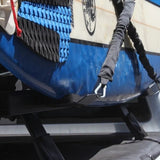 Close-up of a blue and white surfboard secured on a roof rack, with a Front Runner Vertical Surfboard Carrier