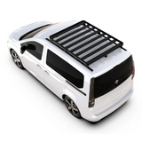 A white minivan shown from a high-angle rear three-quarter view on a clean white background, fitted with a Front Runner Series Volkswagen Caddy (2022-Current) Slimline II Roof Rack Kit.