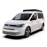 A white Volkswagen Caddy camper van with a black Front Runner Series Volkswagen Caddy / Ford Transit/Tourneo Connect SWB (2020-Current) Slimline II Roof Rack Kit, shown from a three-quarter front angle on a clean white background.