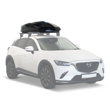 A white SUV with a Front Runner Cargo Carrier / 450 Black roof-top cargo box mounted on a roof rack, shown against a plain white background.