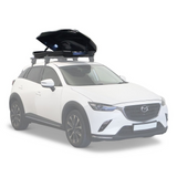 A white SUV with an open black Front Runner Cargo Carrier / 450 roof-top cargo carrier box mounted on a roof rack, shown against a plain white background.