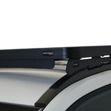 Close-up of a Front Runner Toyota Corolla Cross (2020-Current) Slimline II Roof Rack Kit mounted to a silver vehicle roof, with a small FRONT RUNNER logo badge visible on the crossbar.