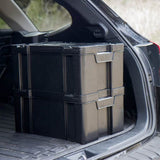 Two stacked black Front Runner Cub Pack Ammo Box plastic storage boxes with integrated handles sitting in the open trunk of a vehicle.