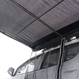 A white SUV with a dark blue Front Runner Series Easy-Out Awning Mosquito Net for a 2M or 2.5M awning, attached to the side, shown from below, on a plain white background.