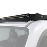 A black roof-mounted LED light bar installed on the roof rack of a white vehicle, shown against a plain white background.