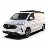 A white Ford Transit van with a Front Runner Ford Transit Custom LWB (2023-Current) Slimline II Roof Rack Kit, shown from a three-quarters front angle on a clean white background.