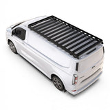 A Front Runner Ford Transit Custom LWB (2023-Current) Slimline II Roof Rack Kit mounted on the roof of a white Ford Transit van, shown from a high-angle studio perspective on a white background.