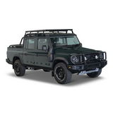 A dark green off-road pickup truck with aFront Runner Ineos Grenadier Quartermaster Slimline II Roof Rack Kit, front bumper guard, and off-road tires, shown from a three-quarter angle on a white background.
