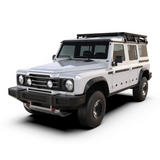 A white off-road SUV with a Front Runner Ineos Grenadier (2022-Current) Slimline II 3/4 Roof Rack Kit, black front bumper, and black trim, shown from a three-quarter front angle on a white background.