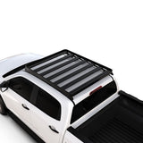 A black Front Runner Series Isuzu D-Max (2020-Current) Slimline II Roof Rack Kit / Low Profile mounted on the roof of a white pickup truck, shown from a high-angle studio view against a plain white background.
