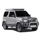 A silver Suzuki Jimny SUV with a black Front Runner Suzuki Jimny (1998-2018) Slimline II Roof Rack Kit and a silver bull bar on the front, shown from a three-quarter angle against a plain white background.