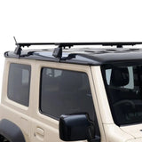 A Front Runner Suzuki Jimny (2018-Current) Load Bar Kit mounted to the roof of a beige SUV, shown against a plain white background.
