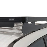 A Front Runner Toyota Land Cruiser 300 Slimline II Roof Rack Kit mounted to a white vehicle roof, with a small 'FRONT RUNNER' label visible on the left side.