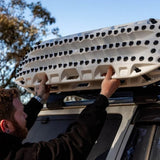 A man installing MAXTRAX XTREME / White Limited Edition onto the roof of a vehicle outdoors.