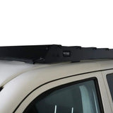 A black Front Runner Front Runner Volkswagen T5/T6/T6.1 Transporter SWB (2003-2024) Slimsport Roof Rack Kit mounted to the roof of a light-colored vehicle, shown against a plain white background.