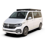 A white Volkswagen camper van with a black Front Runner Volkswagen T6/T6.1 Caravelle Transporter SWB (2015-Current) Slimline II Roof Rack Kit, shown from a three-quarter front angle on a clean white background.