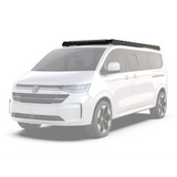 White van with a Front Runner Volkswagen T7 Transporter Caravelle LWB (2025-Current) Slimsport Roof Rack Kit / Light Bar Ready mounted on the roof, on a white background