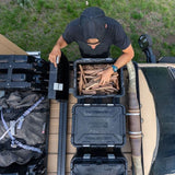 Front Runner Wolf Pack Pro Ammo Box being opened by a person, on a roof rack 