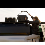 A woman adjusting a water tank on a Front Runner Roof Rack, mounted to a RSI Double Cab Smart Canopy