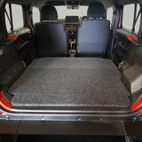Red Suzuki Jimny with open door and the Front Runner Suzuki Jimny 5 Door Base Deck installed.