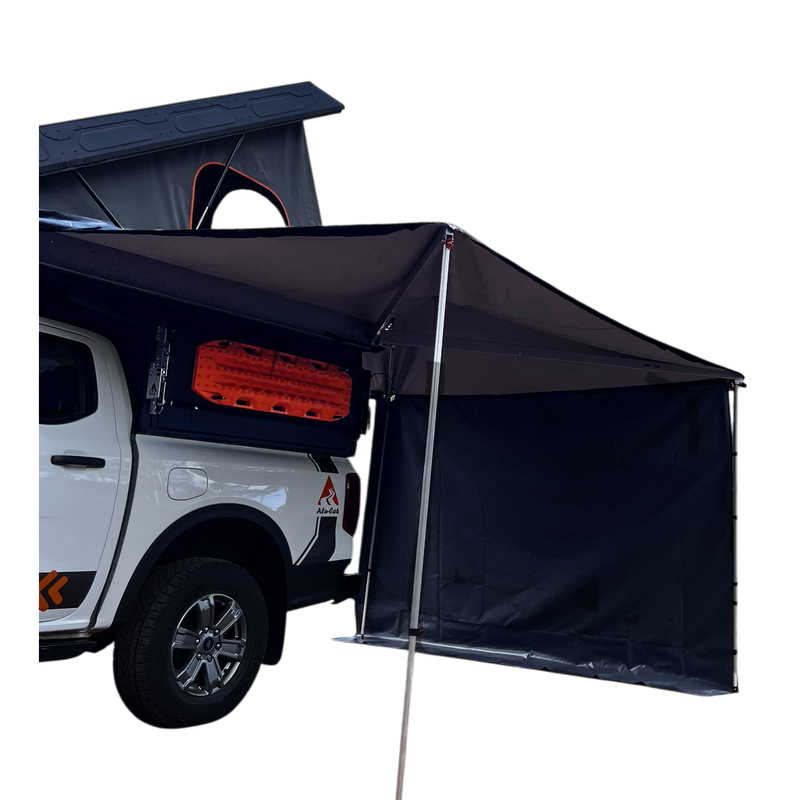 Off-road camping vehicle fitted with a hard shell rooftop tent and an Alu-Cab 270 awning, with the universal side panel in place
