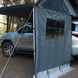 Car with a RoofPod Awning side, mounted tent attached to it in the forest