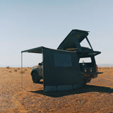 Car with a RoofPod Awning side, mounted tent attached to it in the desert 