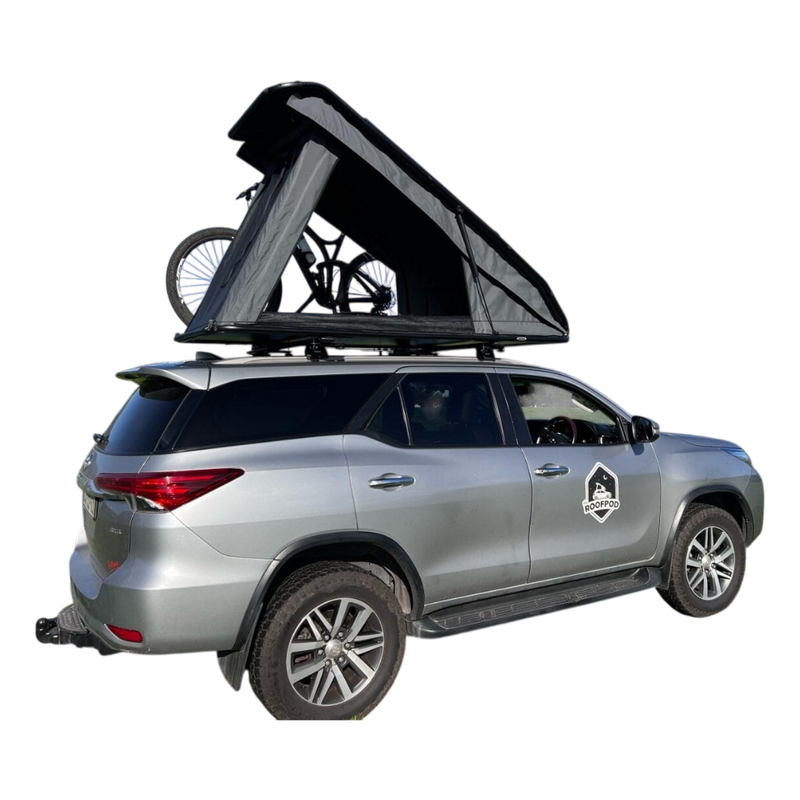 Silver SUV with a RoofPod SoloPod rooftop tent and bicycle on a white background