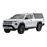 Main view of the Alu-Cab Contour Canopy, without side windows, for the 2026+ Toyota Hilux Extra Cab, mounted on the vehicle, on a white background